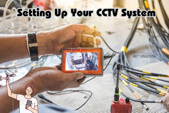 Technician configuring a CCTV system with a handheld tester amidst cables, illustrating MIT Solution's professional installation services in Dindigul.