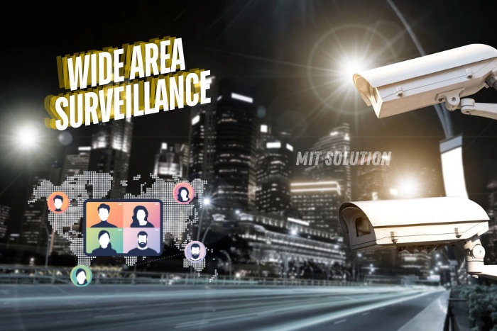 CCTV cameras monitoring a cityscape at night, highlighting MIT Solution's expertise in wide area surveillance systems in Dindigul, Tamil Nadu. The caption 'Wide Area Surveillance' emphasizes the comprehensive security coverage provided by MIT Solution for large urban areas