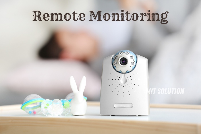 Close-up of a modern baby monitor camera with a sleeping child in the background, showcasing the capabilities of remote monitoring for families. The camera is placed on a table alongside baby pacifiers and a toy bunny, highlighting the importance of safety and peace of mind. MIT Solution offers reliable remote monitoring solutions for homes and businesses in Dindigul